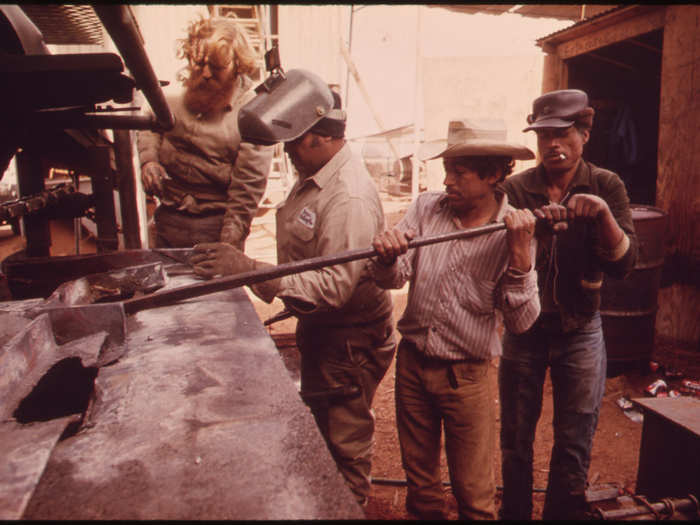 Workers from Mexico at a Cedar Mill near Leakey, Texas, as a Supervisor Stands by near San Antonio 12/1973