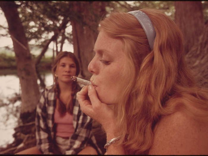 One Girl Smokes Pot While Her Friend Watches During an Outing in Cedar Woods near Leakey, Texas. (Taken with Permission) near San Antonio. One of Nine Pictures 05/1973