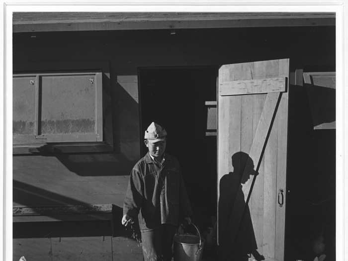 Here, Mori Nakashima scatters chicken feed in front of a chicken coop.