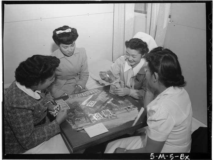 This picture of women playing cards shows the different backgrounds and roles of the camp