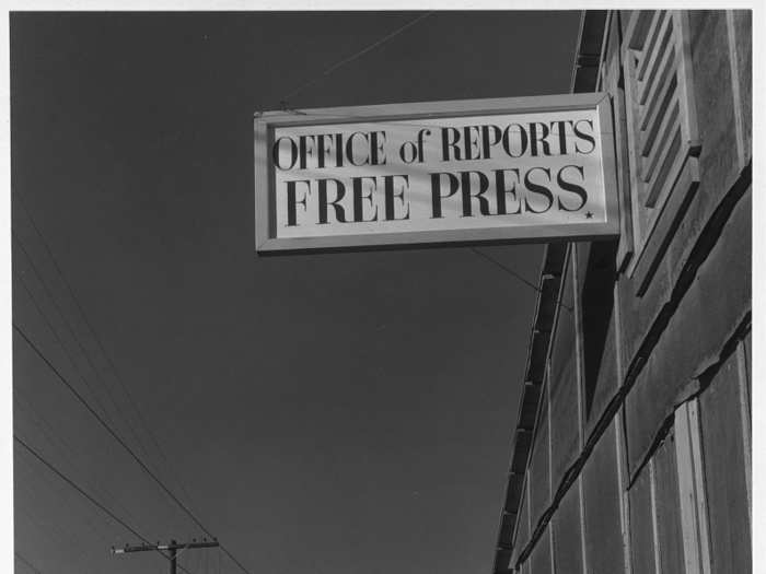 Manzanar even had its own newspaper. Here, editor Roy Takeno reads outside of his office.