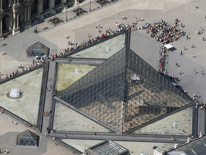 The line for the Louvre wraps around the iconic pyramid, which marks the entrance to the famed art museum.