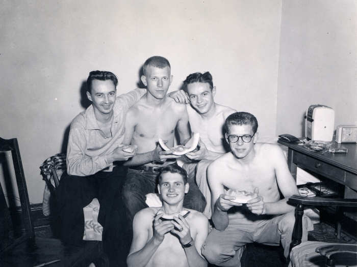 Just a bunch of guys hanging out, eating melon, in this 1950s image.
