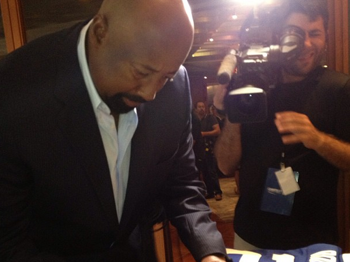 Former NBA Player Mike Woodson autographing a basketball. He