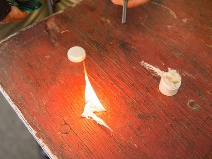 Using a piece of steel and a shard of flint rock, Barry sends a cascade of sparks onto the cotton until it catches fire.