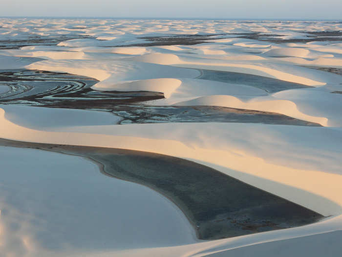 At first glance, the Lencois Maranhenses Sand Dunes of northeastern Brazil look like your average sand dunes, but the valleys are filled with water since the low-lying lands often flood during the wet season. Fish even live in the pools.