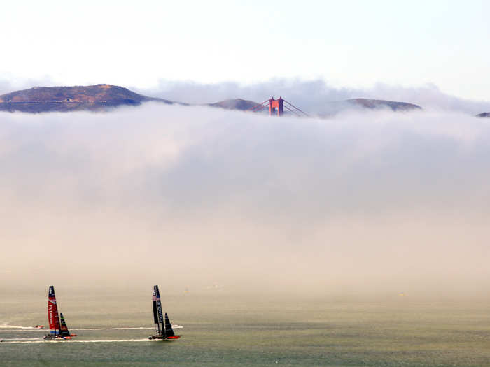 A wall of fog between the boats and the bridge.