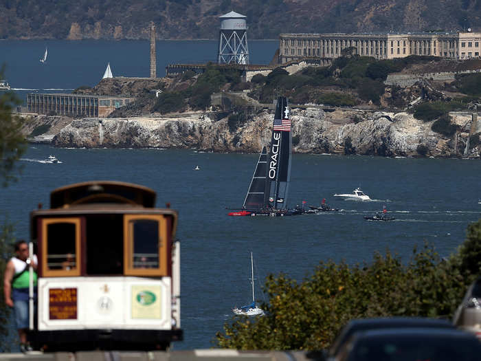 Team Oracle sails away from a cable car.