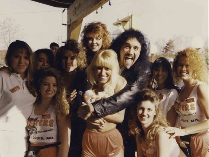 Kiss artist Gene Simmons poses with some Hooters girls.