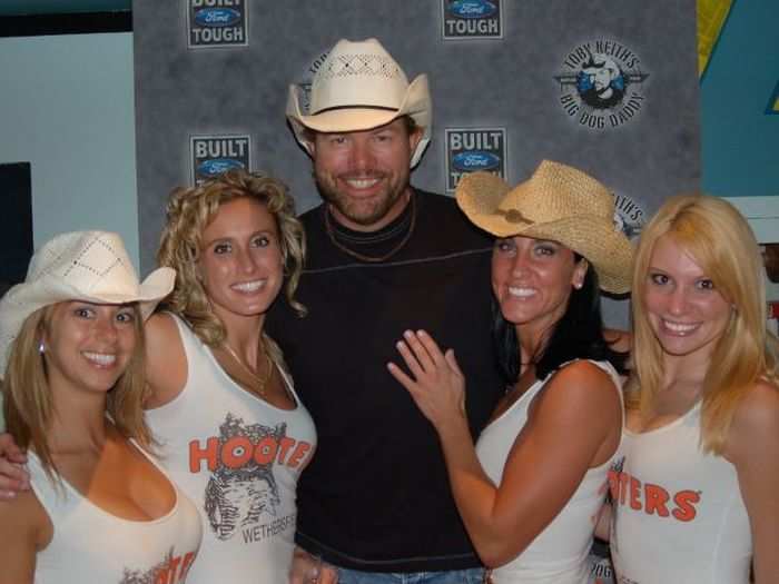 Hooters girls pose with country singer Toby Keith.