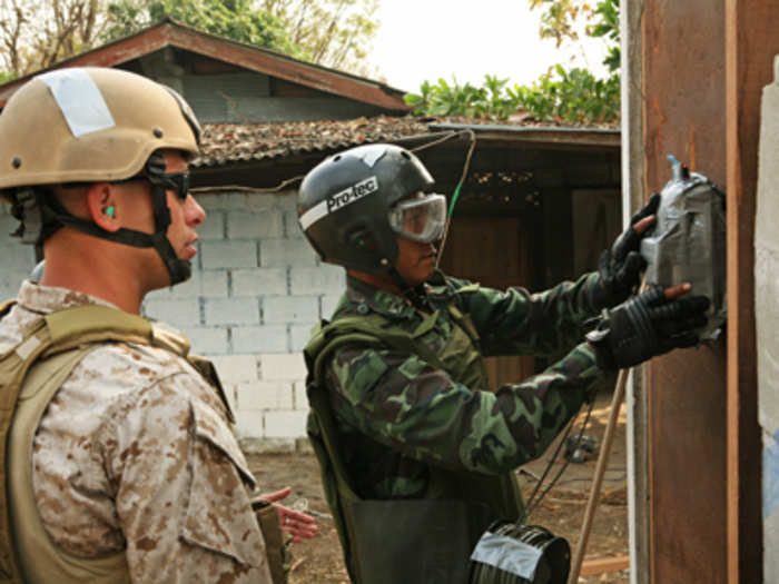 Breaching charges [smaller than in picture] can take a solid steel door right off its hinges