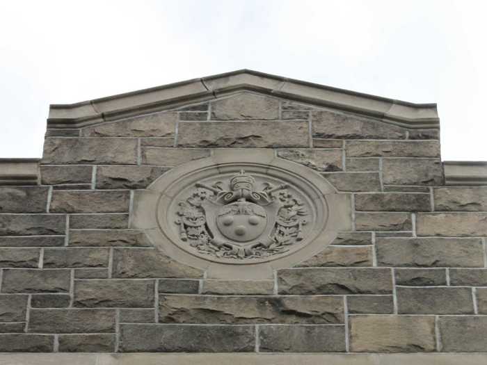 The left side of the building is adorned with the Papal Insignia, showing Fordham