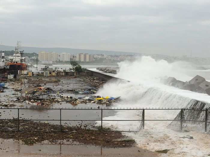 Waves crash onto the shore at a fishing harbour.