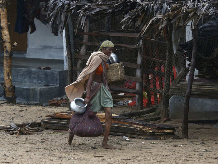 A woman carries her belongings as she leaves her village and walks towards a safer place.