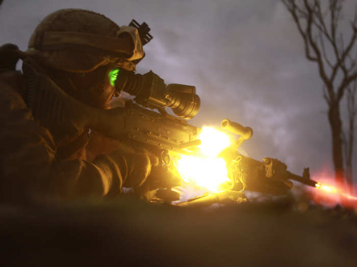 A machine gunner fires an M240 machine gun during a night squad-attack exercise.