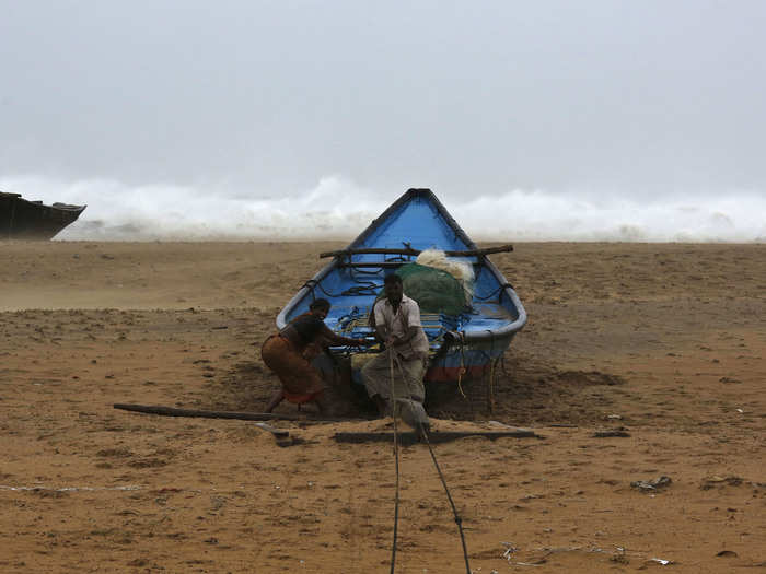 Fishermen tie their boat along the shore before leaving for a safer place at Donkuru village in Srikakulam district, in the southern Indian state of Andhra Pradesh.