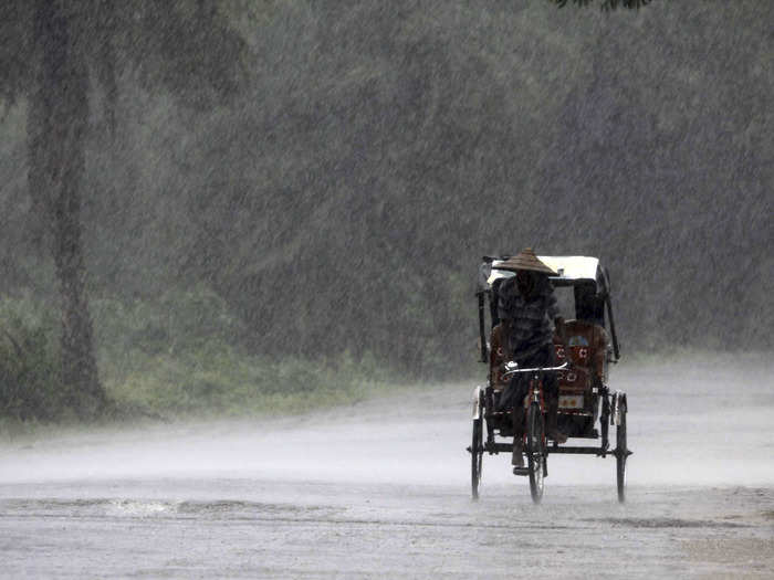 An Indian rickshaw puller carries people to a cyclone shelter near Chatrapur in Ganjam district.