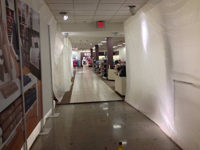 Huge sections of the store are screened off with gloomy, ghostly white tarps.