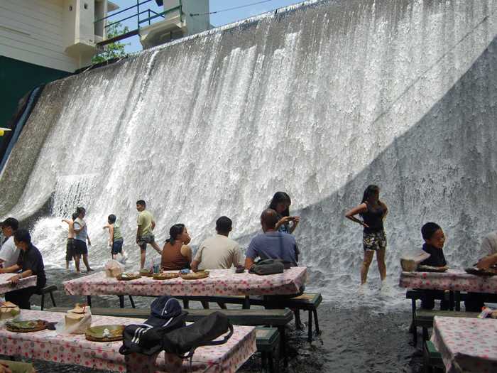 Enjoy a meal with your feet in a waterfall in the Philippines.