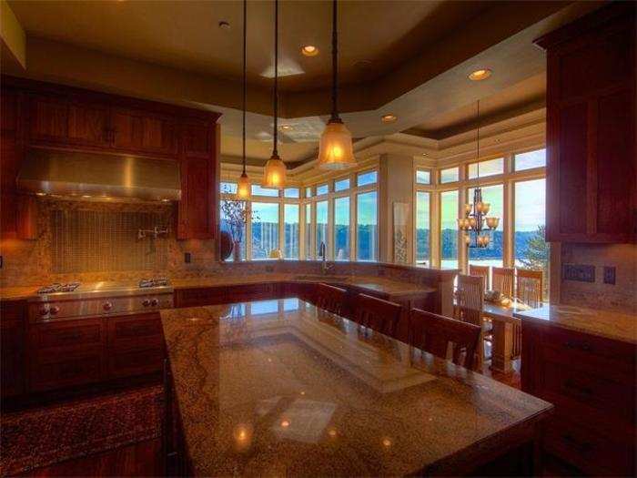 Here is the stunning gourmet kitchen with two sinks, three ovens, two dishwashers, a Wolfe range, custom hidden refrigerator, and slab granite countertops.