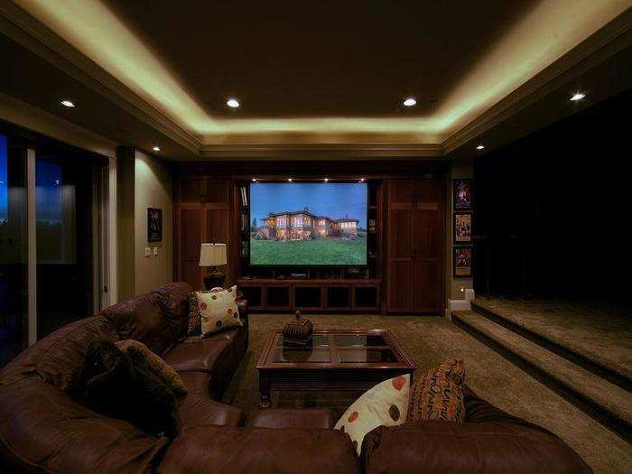 The lower "daylight basement" features high ceilings with floor to ceiling windows in almost every room. This is a picture of the media and family room. The projector and screen hide behind the bookcases when not in use.