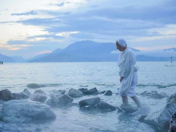 "The name of the nun is Suor Rosalba, which literally could mean Pink Sunrise. The hot sulphur waters of this lake made for an ideal early morning natural spa. I met   Suor Rosalba as she was standing in the spa waters in the dark well before sunrise, we   talked for a while and then the picture shows her leaving to go the first Mass of the day. Taken in Sirmione, Lake Garda, Italy." — Sergio Amiti