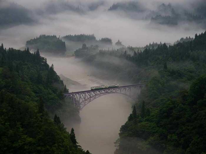 "Taken at Mishima town in Fukushima pref. The first train goes across the railway bridge through in morning mist. The train moves forward little by little slowly." — Teruo Araya