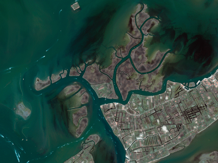 This photo of the Venetian Lagoon in Italy, taken in 2008 by the commercial satellite Ikonos-2, shows the busy waterways and islands northeast of Venice (not visible). The largest island is Saint Erasmus (center right) and Le Vignole (bottom left). The white marks in the lagoon