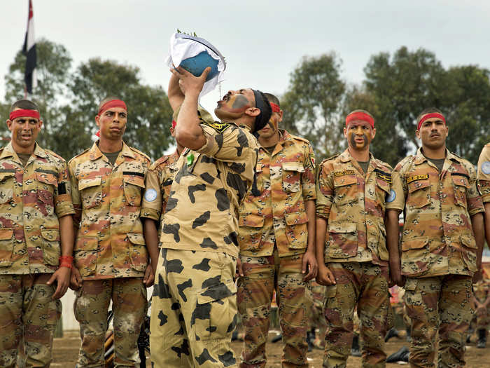 There are more than 20,000 UN troops in Congo. An Egyptian member of MONUSCO demonstrates drinking from his helmet, a survival technique, during a medal ceremony in Bukavu.