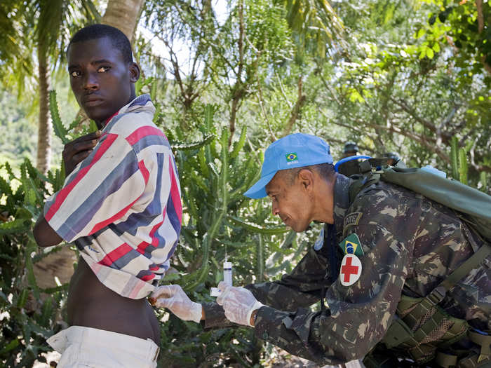 One of the primary objeectives of MINUSTAH is providing medical care and food aid to isolated areas in Haiti. Here, a Brazilian UN troop administers a medical injection.