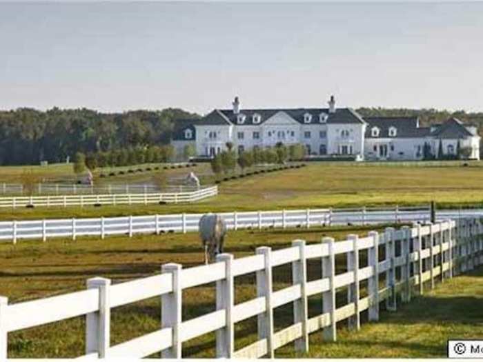 Corraled horses and bright green fields make for an idyllic scene.