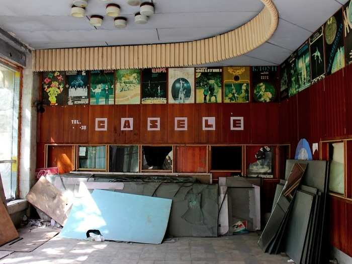 The ticket desk, inside the circus building, displays faded posters for past shows and performances.