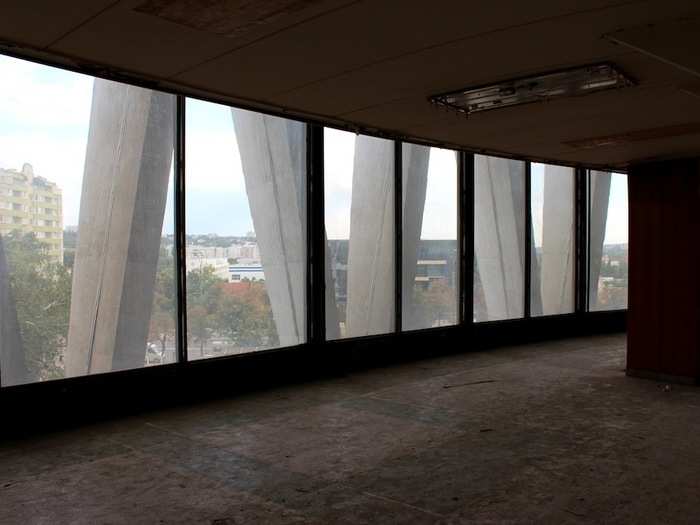 Dirty windows on an upper floor of the circus offer a cityscape view.