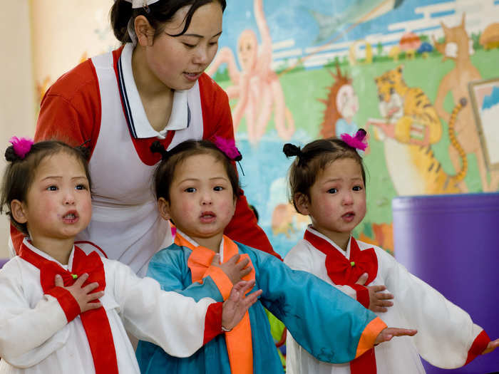 Lafforgue says there are many twins and triplets without parents, like these triplets singing at an orphanage. The official reason is that parents cannot afford to raise 2 or 3 kids at the same time.