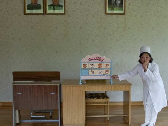 A teacher instructs children at Kim Jong Suk school in Pyongyang, while a child attempts to guess the name of each animal. Other children are forbidden to help.