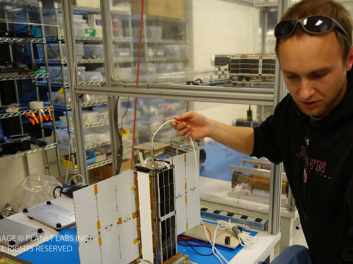 Engineer Ben Howard is testing a satellite. It took less than six months to build 28 of them.