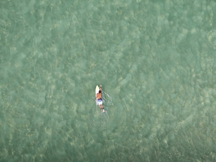 A surfer swims off the coast of Rio de Janeiro.