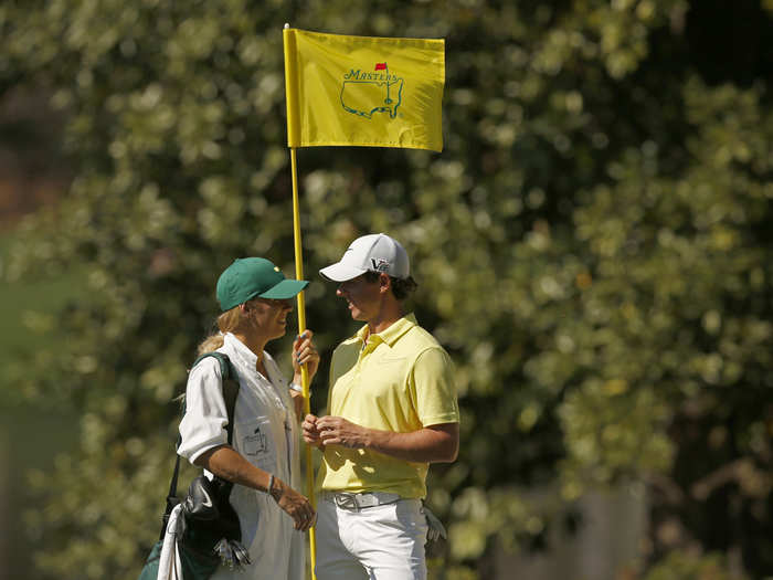 Caroline Wozniacki caddies for Rory McIlroy during practice rounds at The Masters.