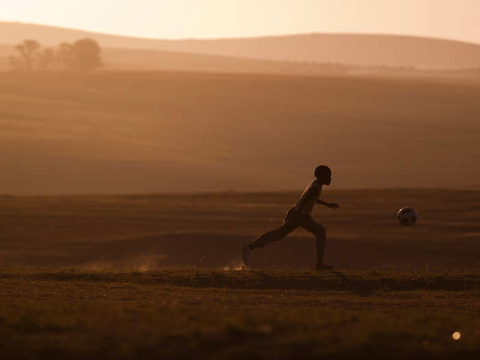 A child plays soccer near the late Nelson Mandela