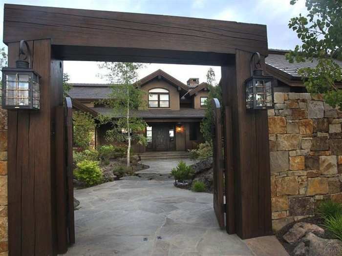 The entrance of the home looks like a medieval fortress with old-school lamps and wooden gate