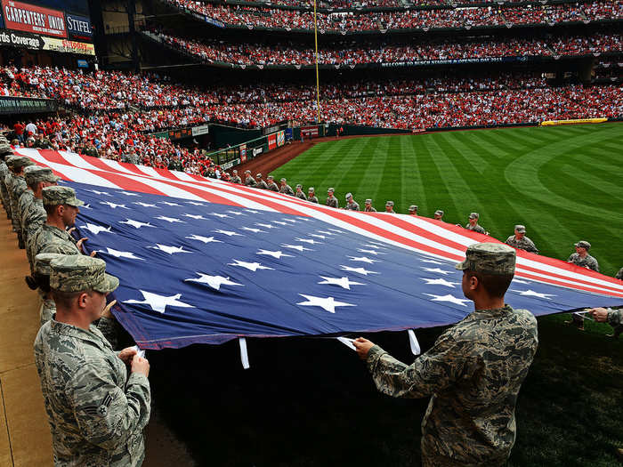 Airmen from the 375th Air Mobility Wing at Scott Air Force Base, Ill., present a giant American flag for nearly 50,000 fans at Busch Stadium, home of the St. Louis Cardinals. Scott AFB Airmen have been involved in numerous community sporting events, but this was the first time they presented the flag at the opening day of the season. (U.S. Air Force photo/ Staff Sgt. Ryan Crane)