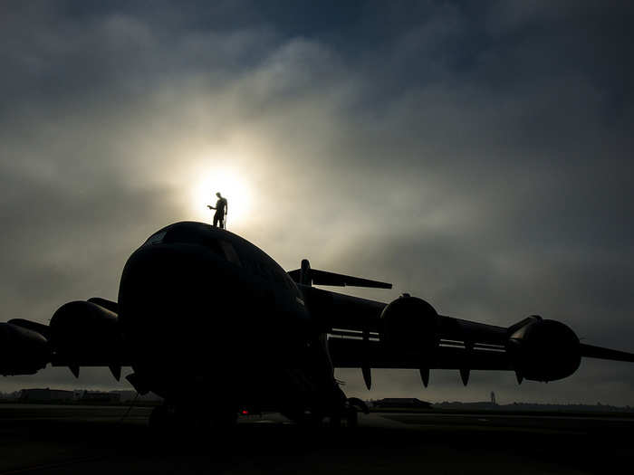 Tech. Sgt. Andrew Gravett walks along the top of a C-17 Globemaster III as he does a routine maintenance check at Joint Base Charleston, S.C. The first C-17 to enter the Air Force’s inventory arrived at Charleston Air Force Base in June 1993. Gravett is a crew chief with the 437th Aircraft Maintenance Squadron at JB Charleston. (U.S. Air Force photo/Senior Airman Dennis Sloan)