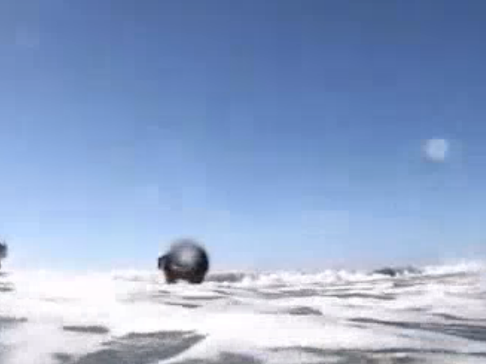 Two sailors are sucked into a rip current and lose control as waves continuously pound against them. A rip current can carry a strong swimmer as fast as 8 yards per second out to sea.