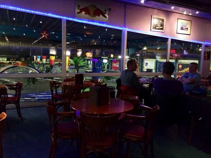 Dining tables, video games, a bowling alley, a mechanical bull riding machine, pool tables, 3-D movie theater, and a bar overlook the track.