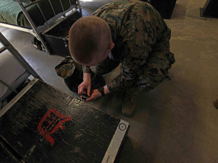 As soon as we come in, I ask him to unlock his footlocker. This is a motion he has done so many times under stress that he could probably do it in his sleep. Also, notice that his footlocker is marked on both ends with his name and recruit laundry number. Marines are required to mark their issued gear, and DI