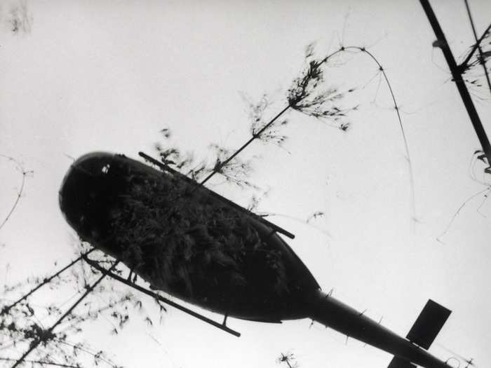 An evacuation helicopter in Vietnam raises the body of an American paratrooper killed in action in the jungle near the Cambodian border in 1966.