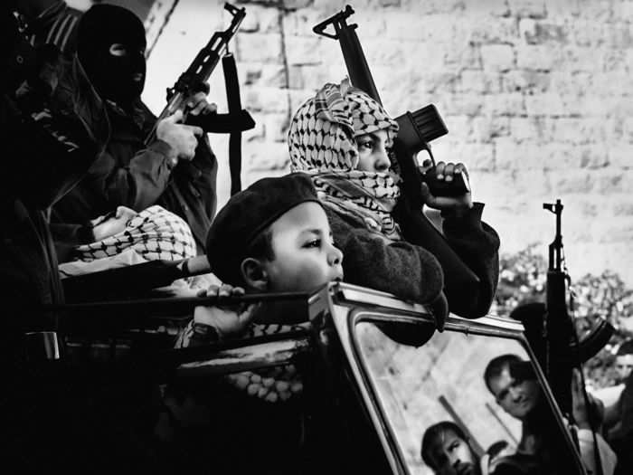 Young members of Fatah, a major Palestinian political party, at the funeral procession of a Palestinian fighter in 2002.