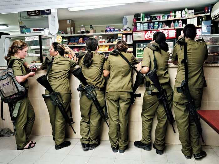 Military service is mandatory for all Israelis. Fifteen years after completing her own service, Israeli photographer Rachel Papo documents young female soldiers buying things at a military kiosk counter in 2004.