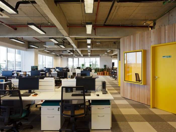 Employee desks surround the central wooden room on each floor.