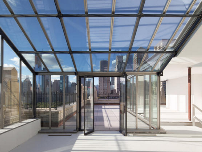 The glass enclosed apartment offers grand views of Central Park and the New York City skyline.